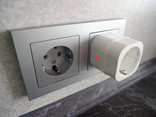 A smart plug connected to a power socket, illustrating home automation devices.